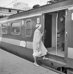 168255 Afbeelding van een treinreizigster tijdens het instappen in het electrische treinstel nr. 1208 (mat. 1957, ...